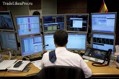 A trader looks at computer screens on the trading floor of Bankinter bank during a Spanish bond auct